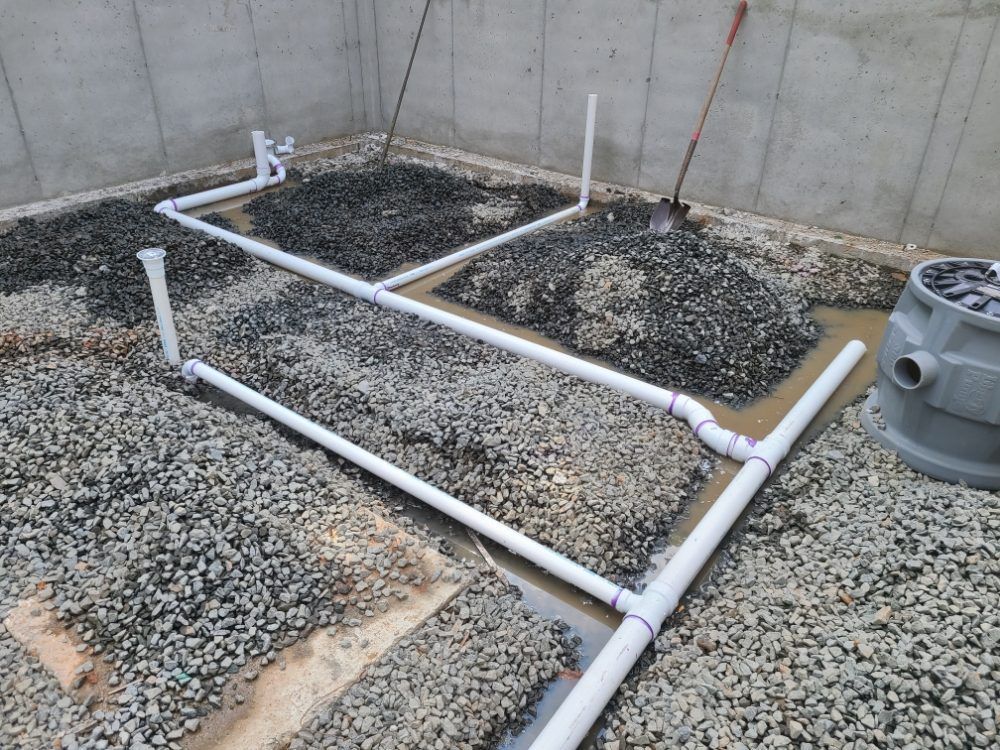 A bunch of pipes are laying on a pile of gravel.