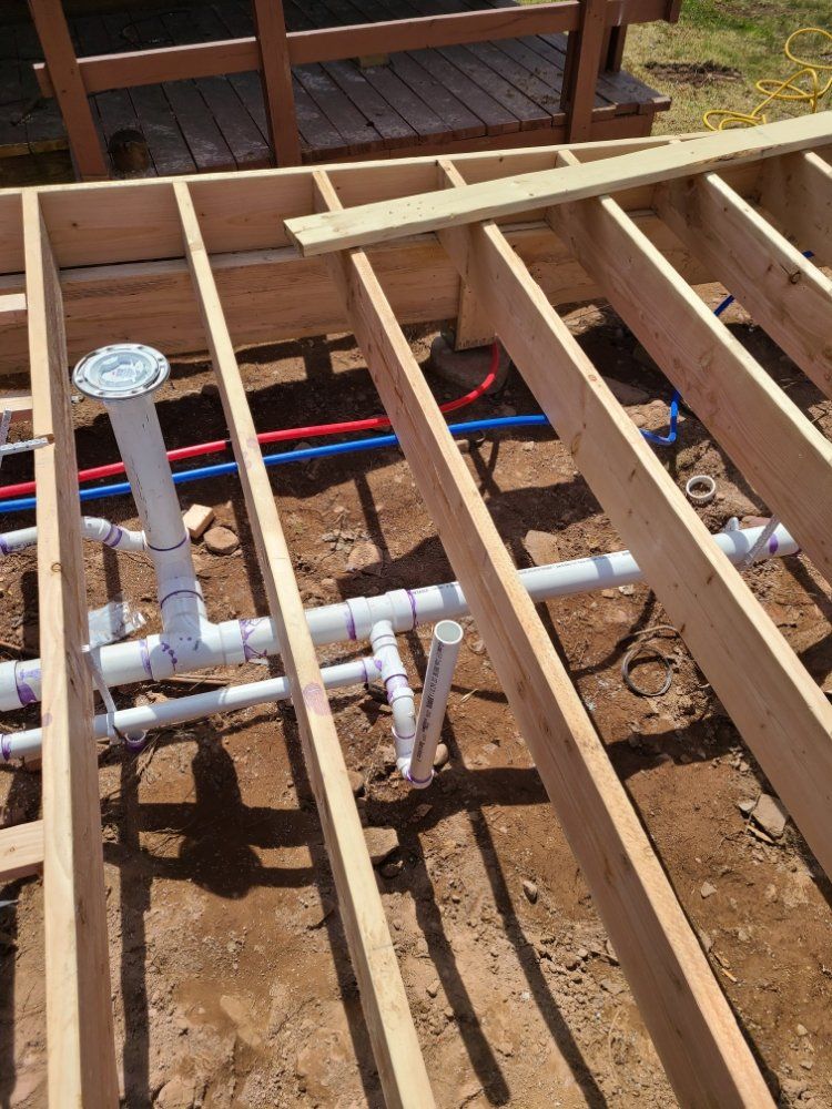 A wooden floor with pvc pipes underneath it