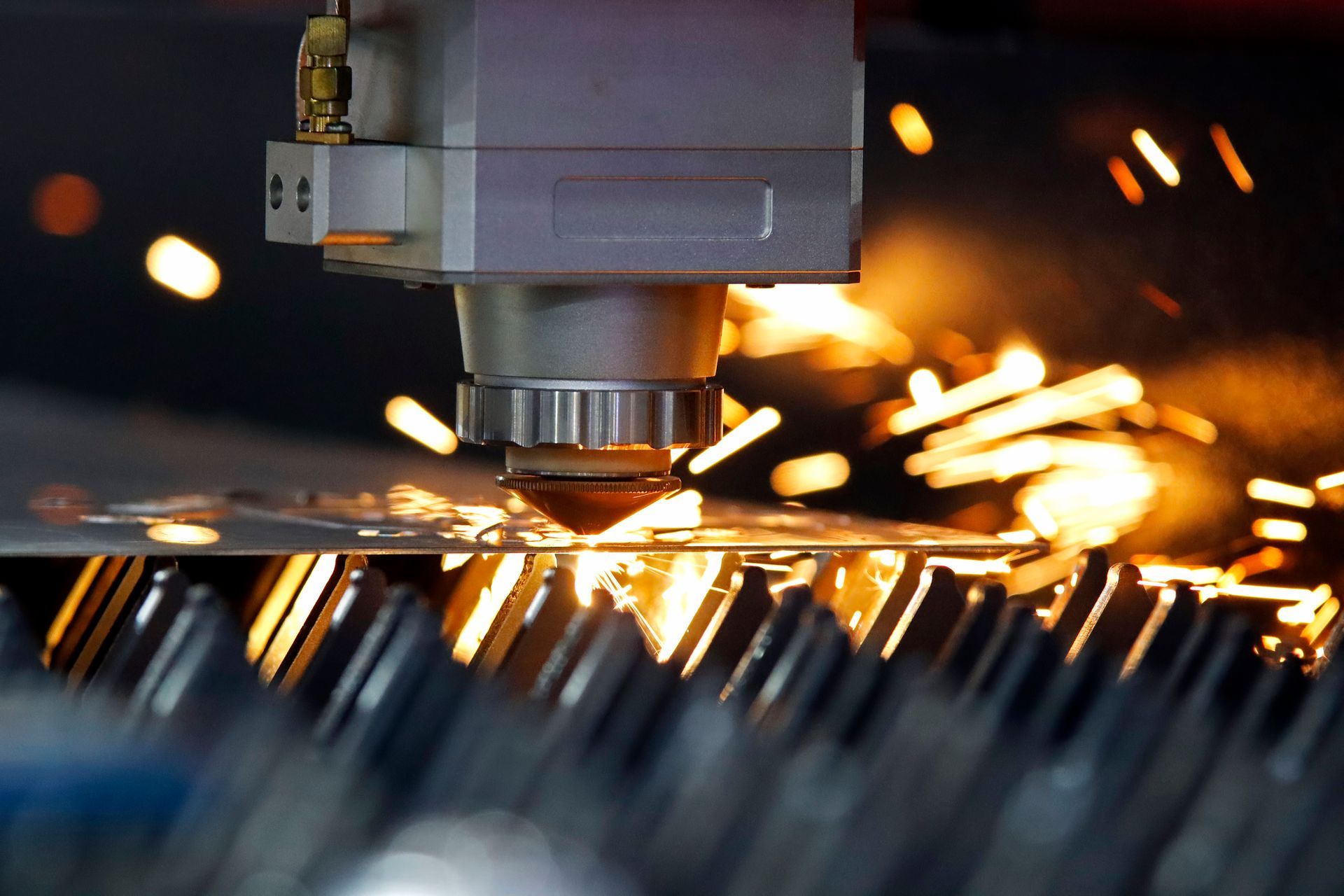 Una macchina taglia un pezzo di metallo e ne escono delle scintille.