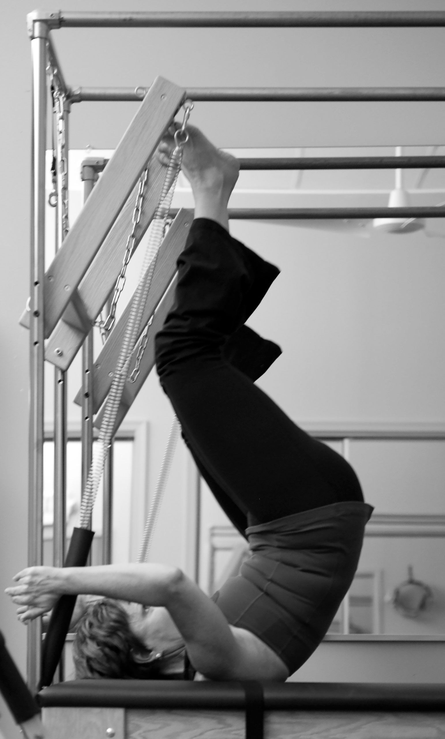 A black and white photo of a person doing pilates