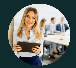 A woman is holding a tablet in front of a group of people.