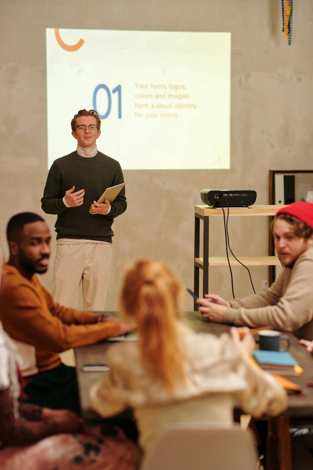 A man is giving a presentation to a group of people sitting around a table.