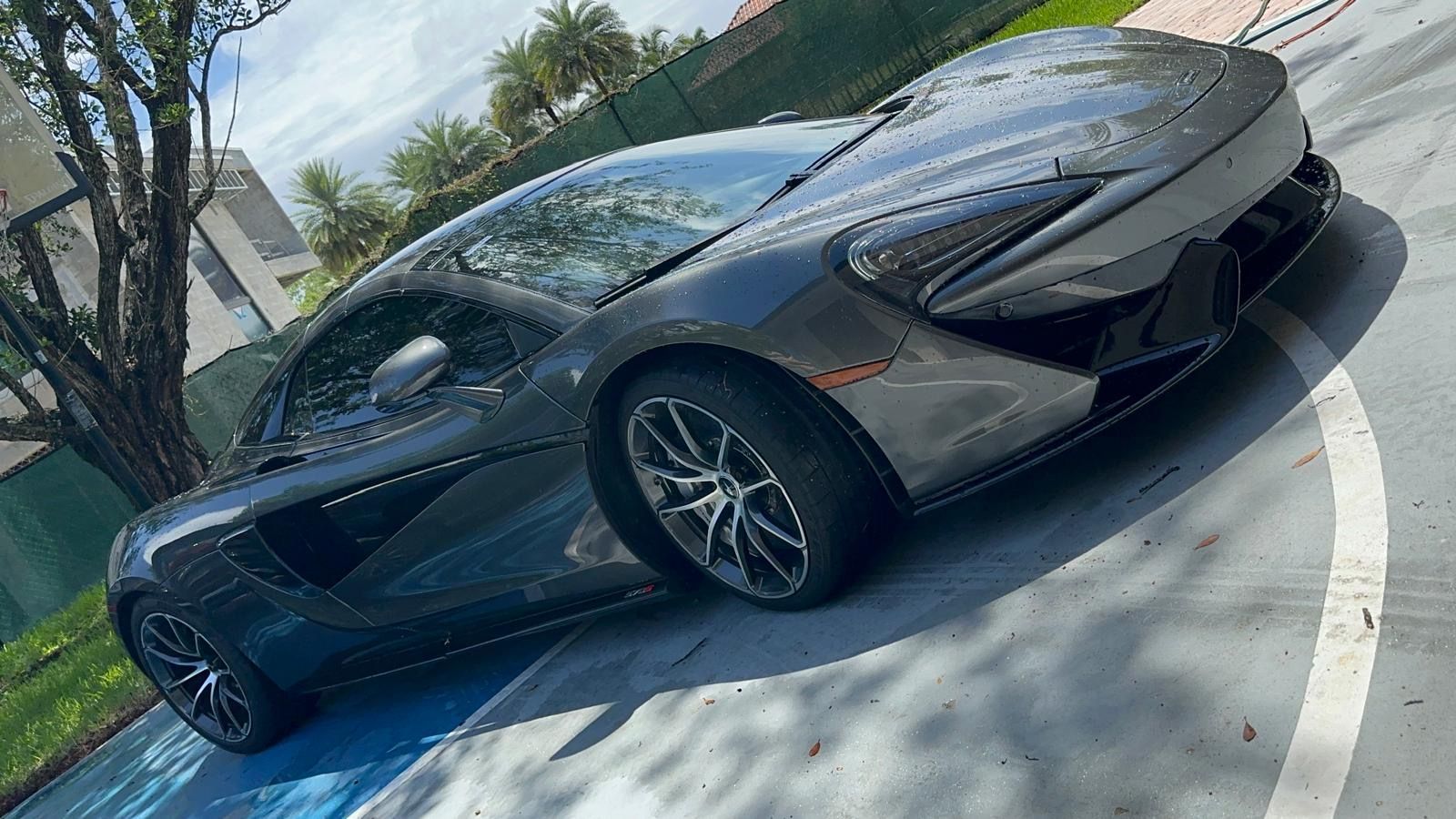 A gray sports car is parked in a parking lot.