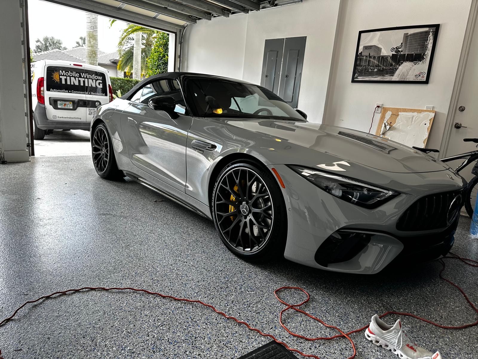 A silver sports car is parked in a garage.