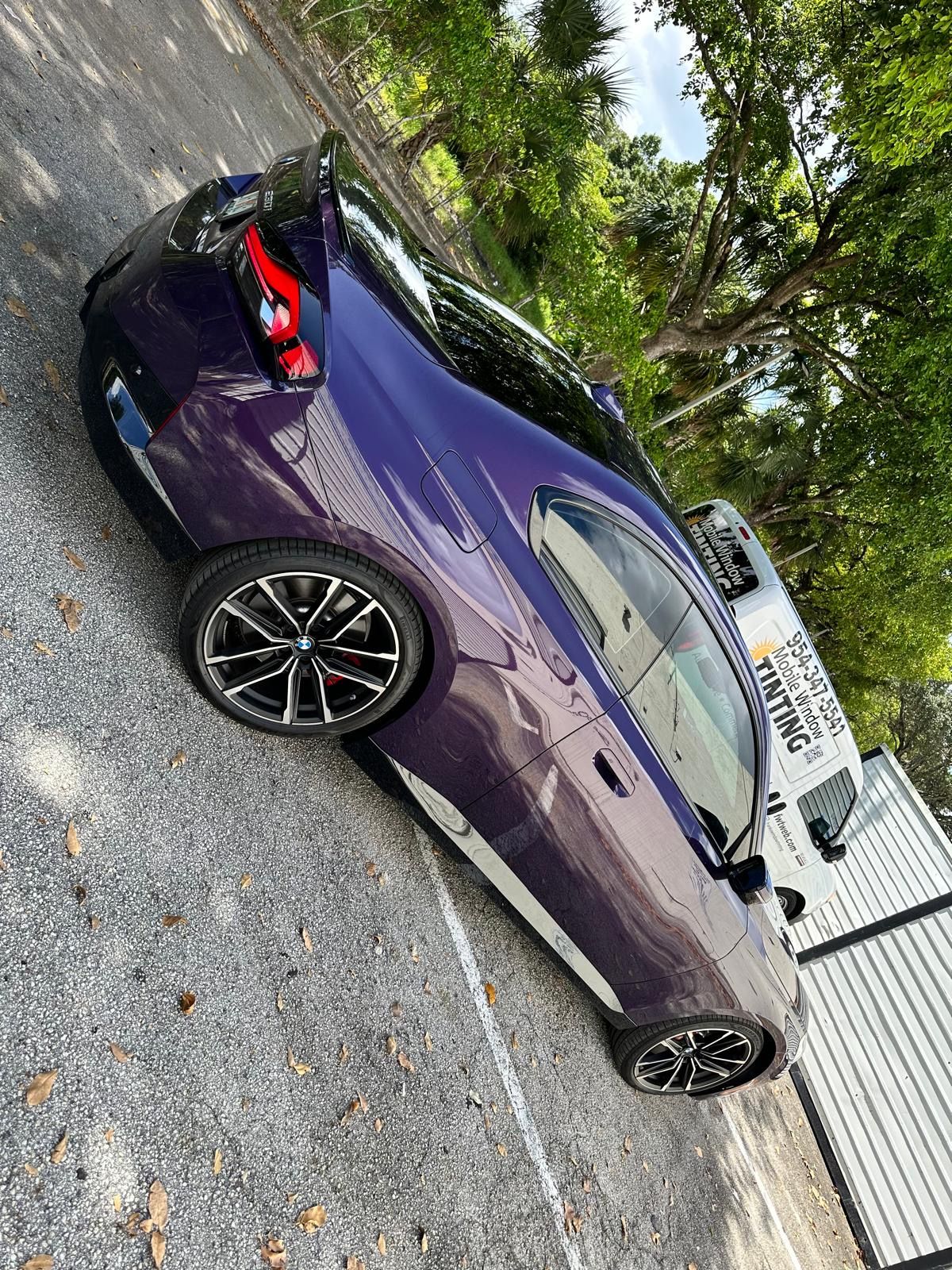 A purple car is parked in a parking lot.