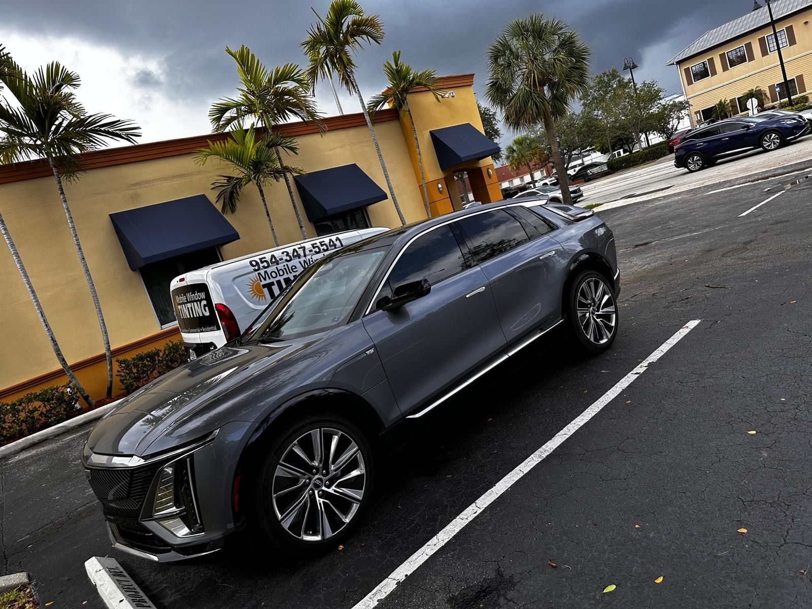 A car is parked in a parking lot in front of a building