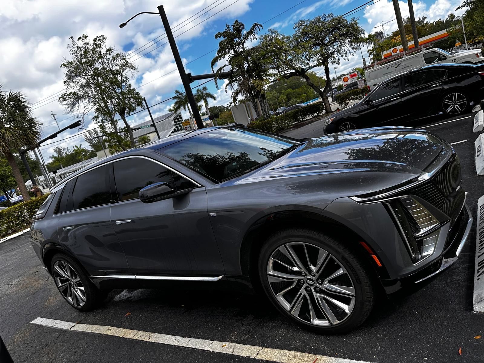 A gray car is parked in a parking lot.