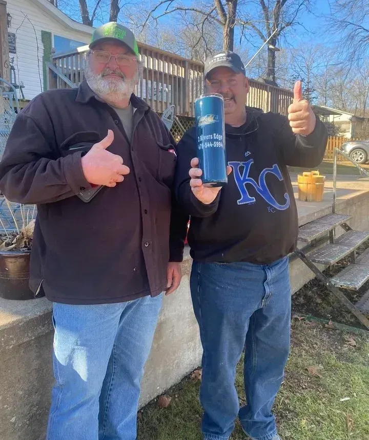 Two men outside, thumbs up. One holds a blue Miller Lite can; one wears a Kansas City Royals sweatshirt.