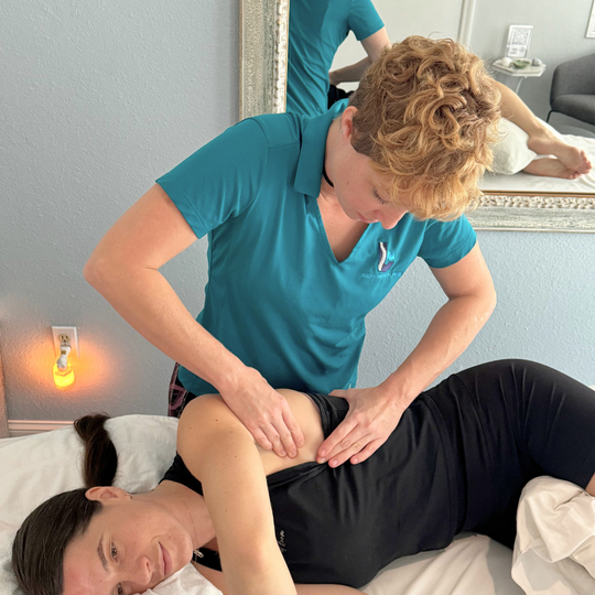 A man in a blue shirt is giving a woman a massage