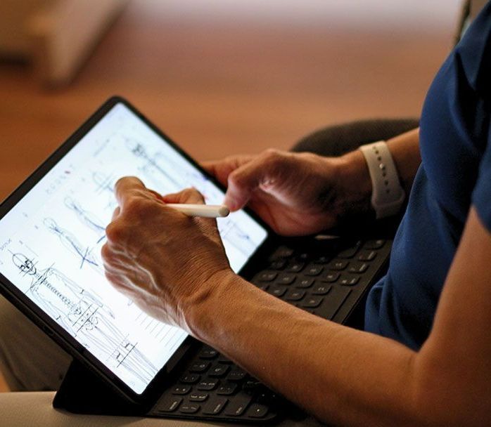 A person is writing on a tablet with a pen