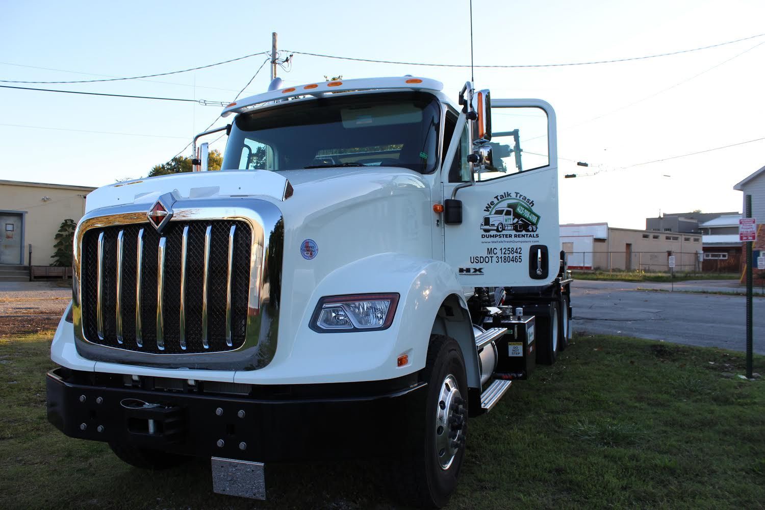 A white semi truck is parked on the side of the road.
