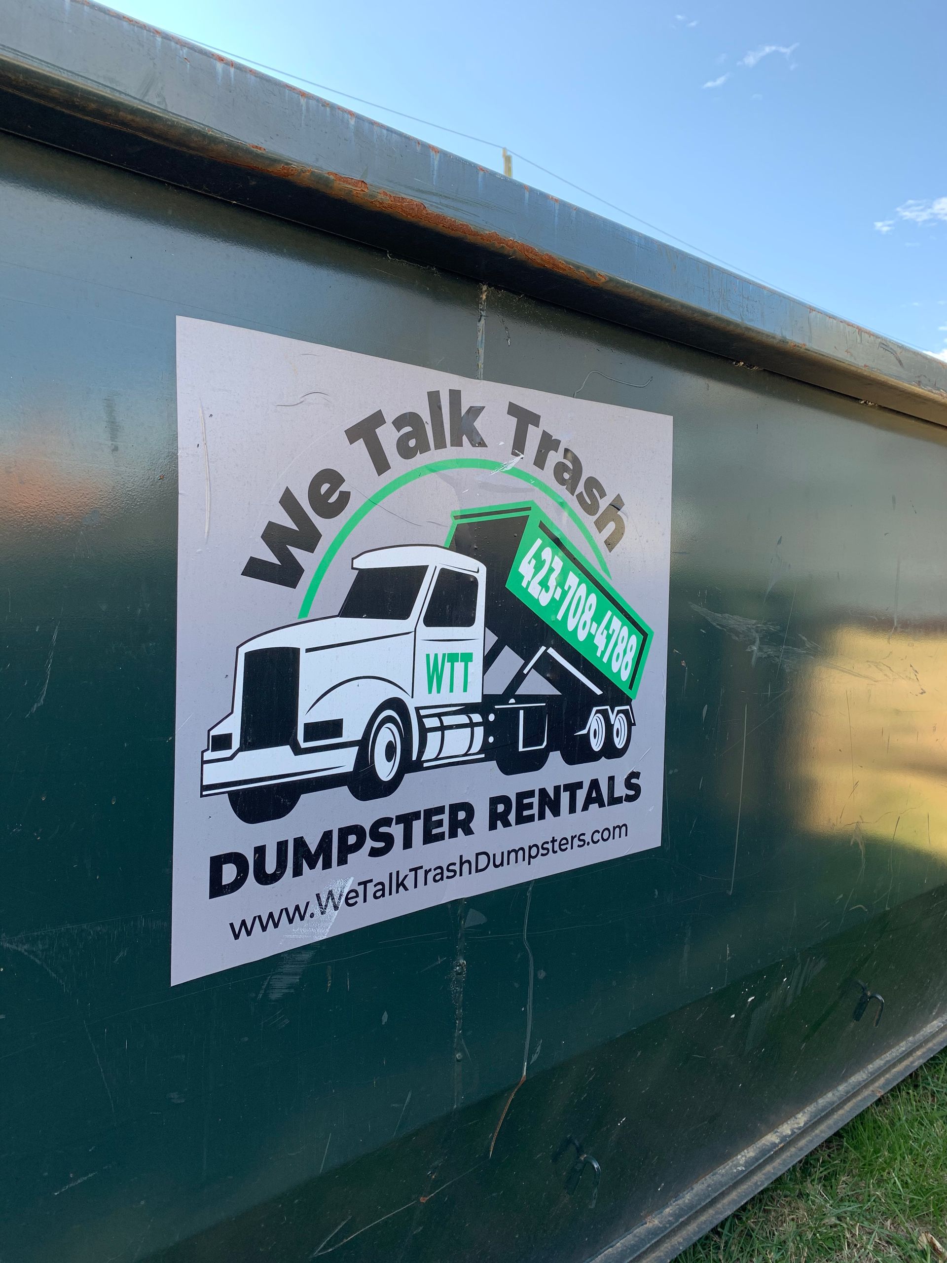 A dumpster with a sign on it that says `` we talk trash dumpster rentals ''.