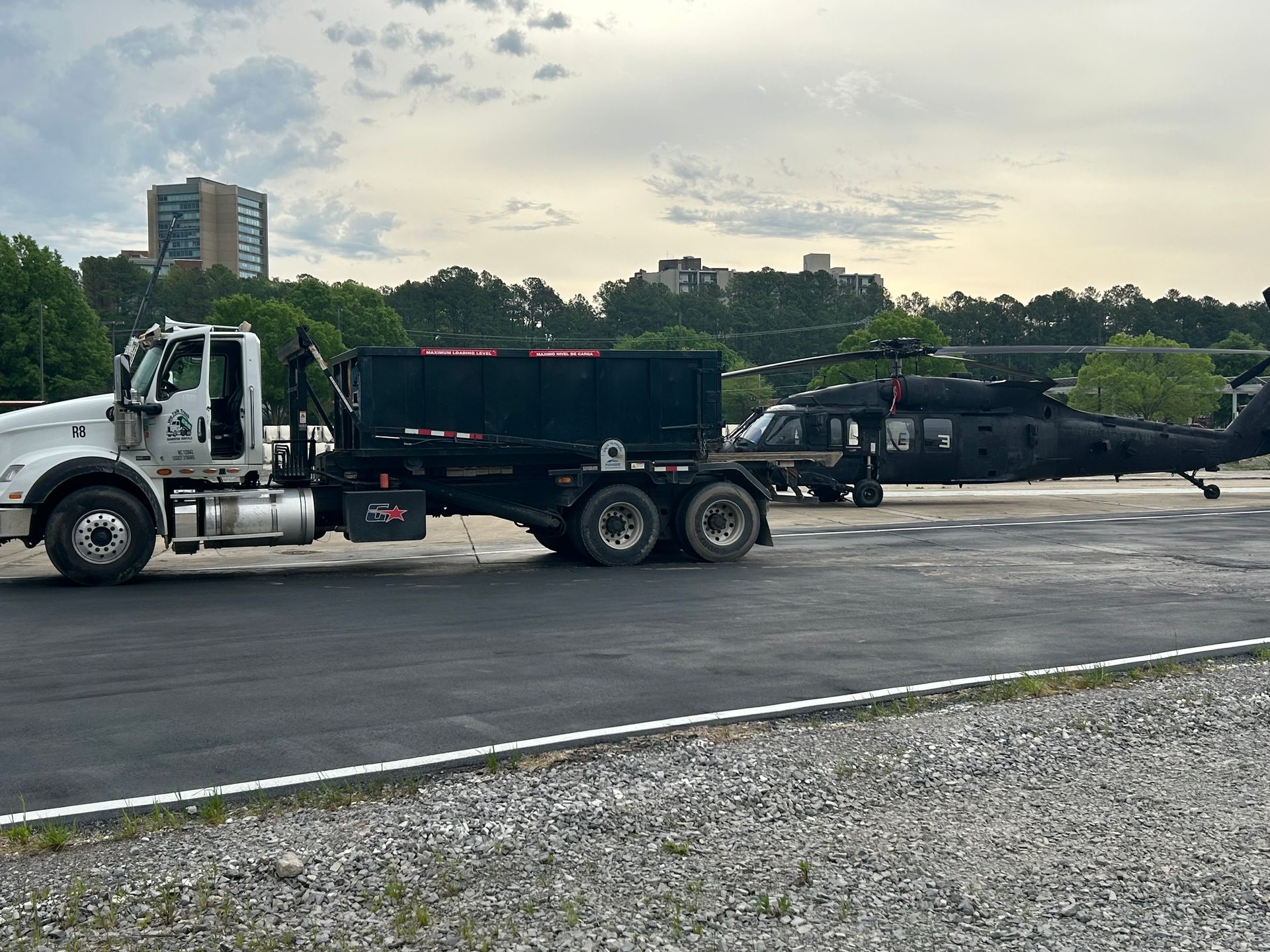 A truck is towing a helicopter down a road.