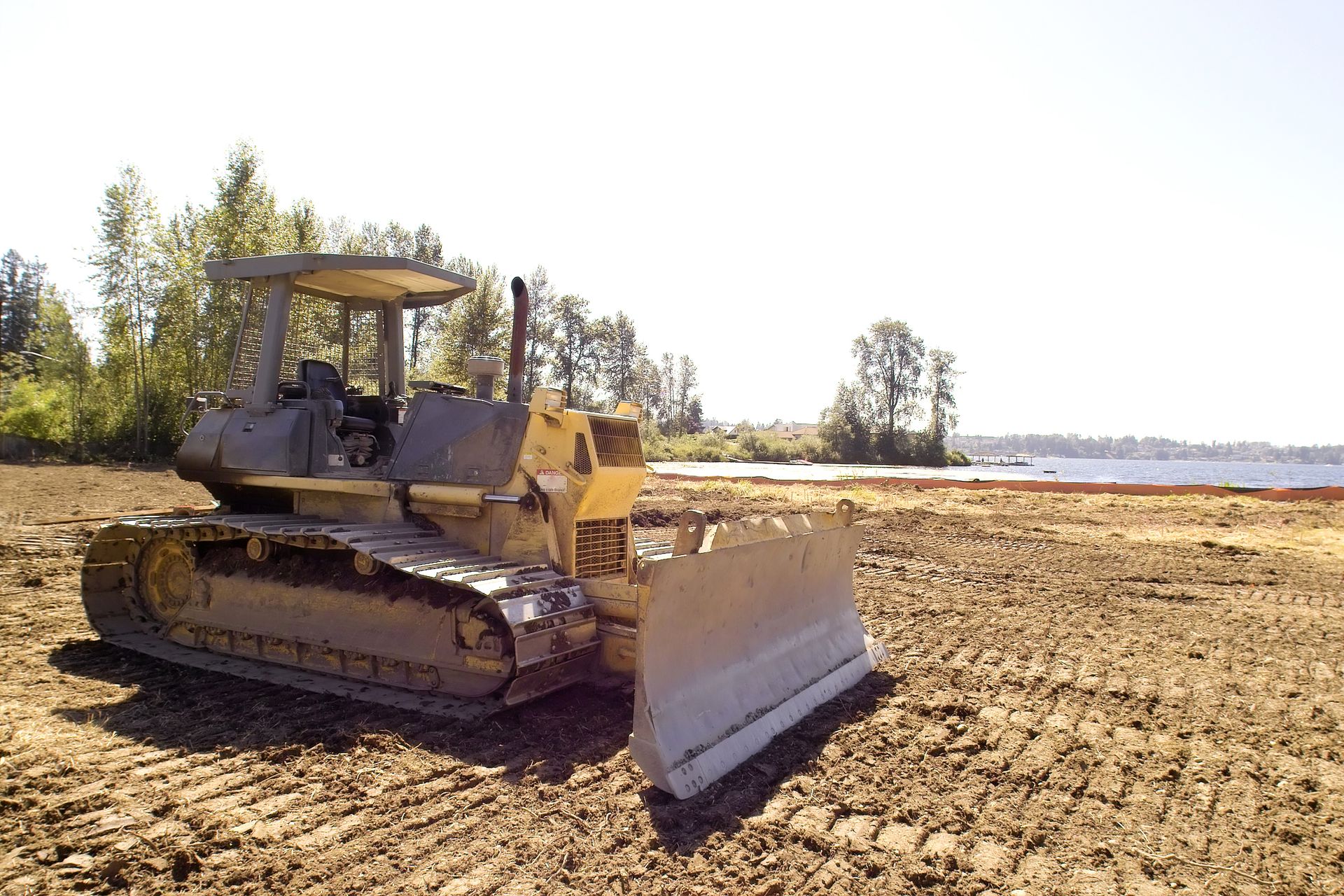A bulldozer is sitting in the middle of a dirt field