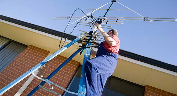 Cable guy working on antenna — About US in Mount Louisa, QLD