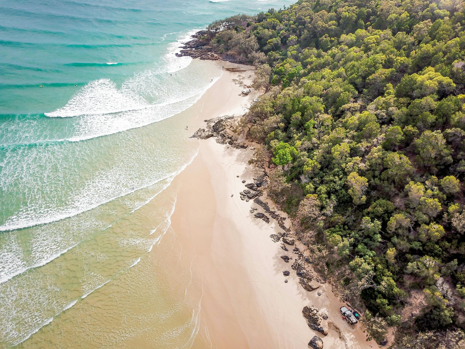 Aerial View of a Beach Surrounded by Trees and Waves — Noosa Mechanical in Noosaville, QLD