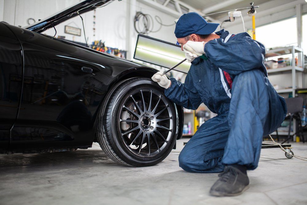 Mechanic Fixing Car's Wheel — Noosa Mechanical  in Noosaville, QLD