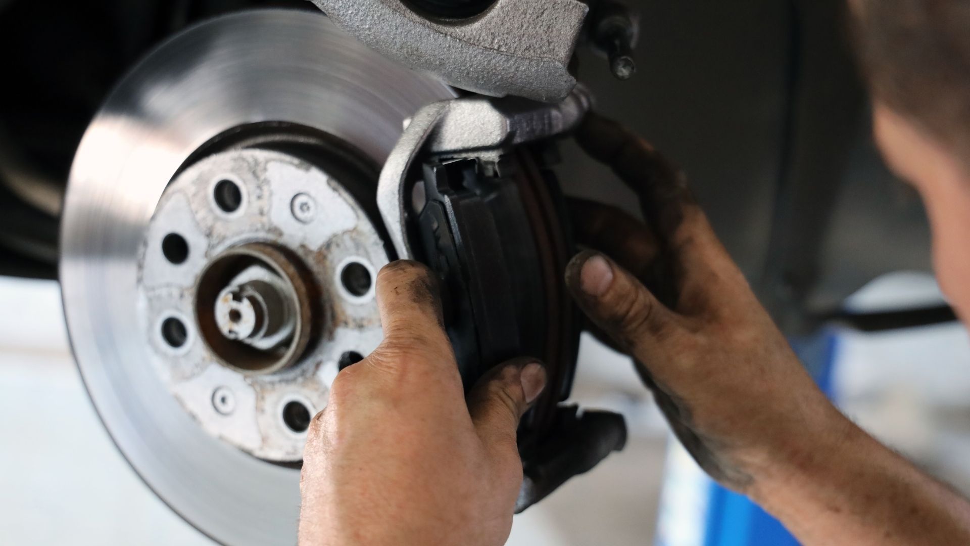 A man is fixing a brake disc on a car.