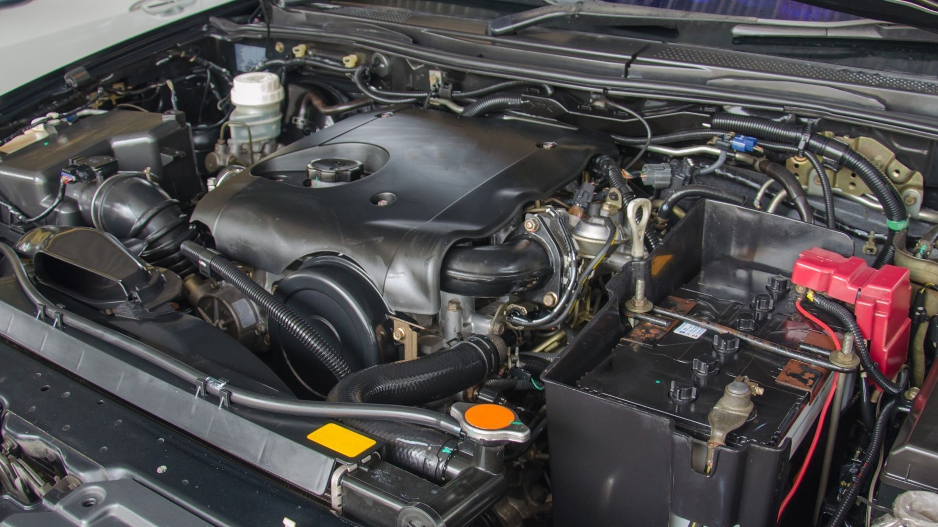 A close up of a car engine with the hood open.