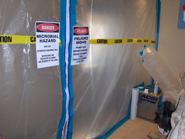 Caution-taped plastic barrier with biohazard signs in a work area