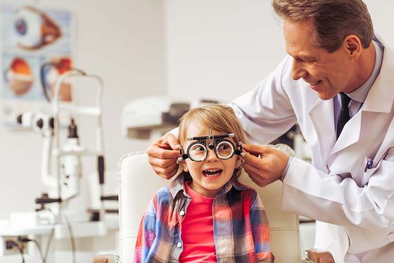 doctor is perfoming the eye checkup of the kid