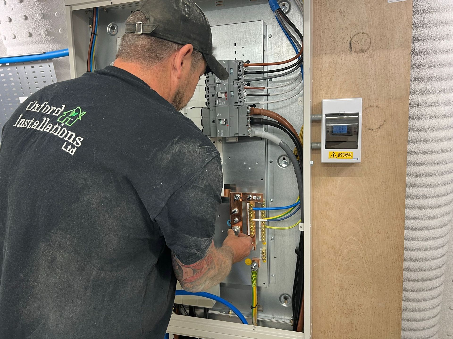 An electrician working on an electrical box in Bicester. 