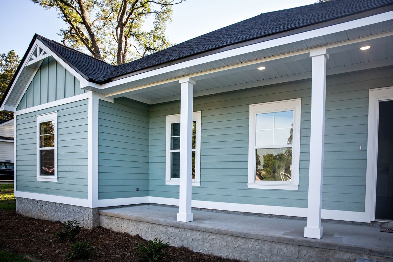 Light blue house with white trim and columns, front porch.