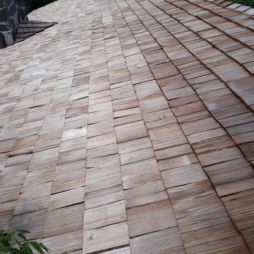 Wooden shingle roof, textured and angled, with varied brown tones in an outdoor setting.