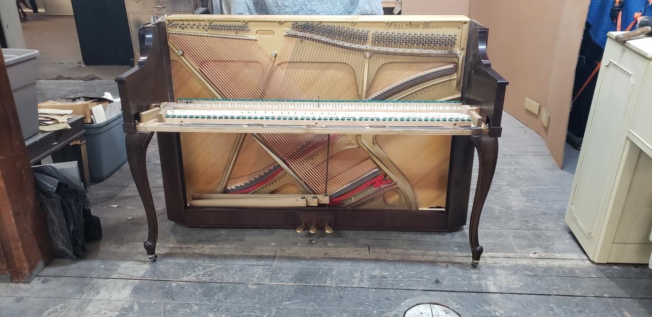 A piano is sitting on the floor in a room.