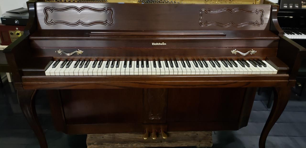 A piano is sitting on top of a wooden table in a room.