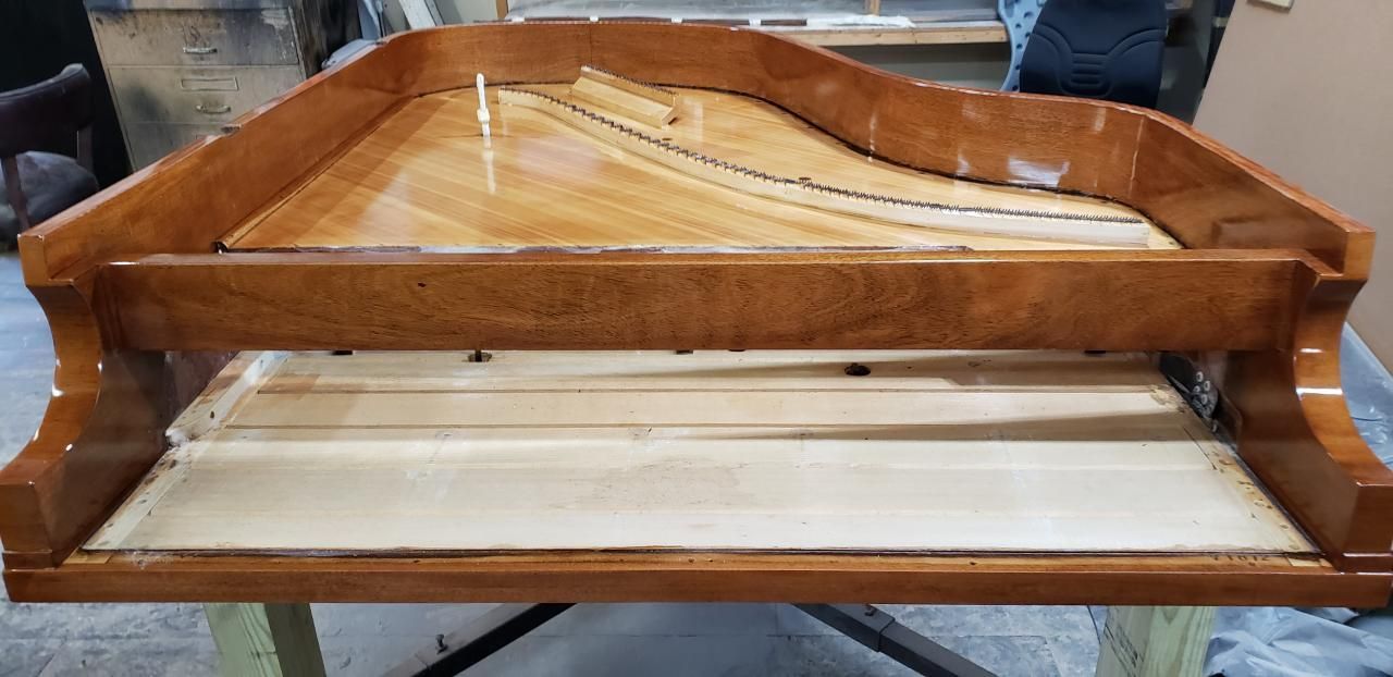 A wooden piano is sitting on top of a wooden table.