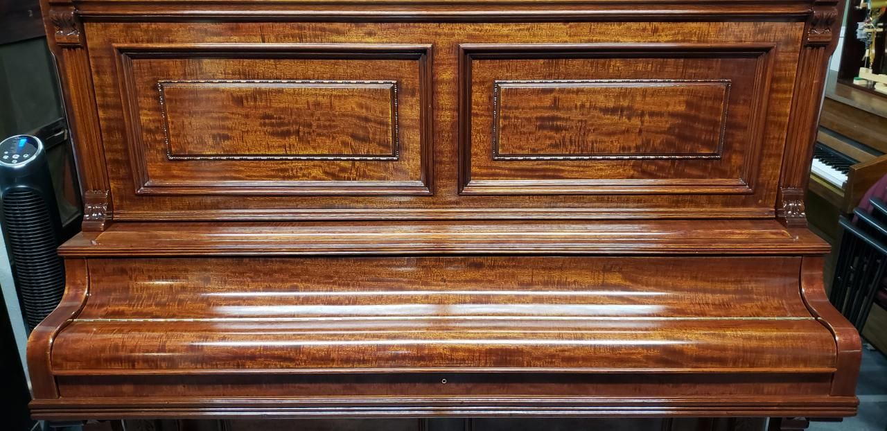 A wooden piano is sitting on a table in a room.