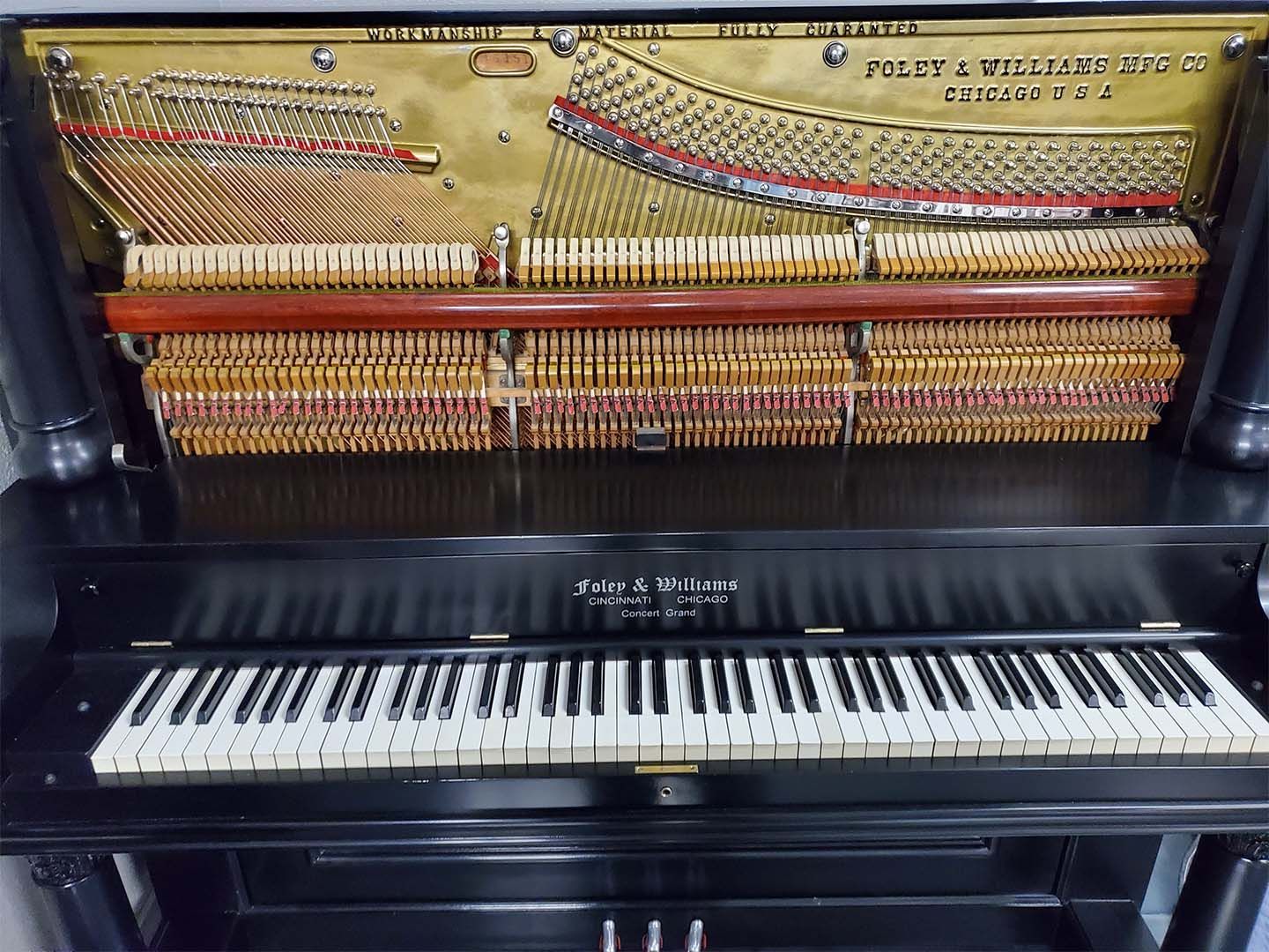 The inside of an upright piano with the keys visible