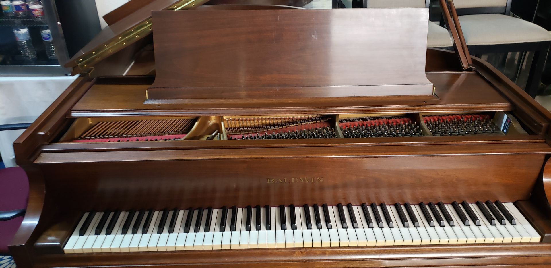 A piano with the lid open is sitting in a room.