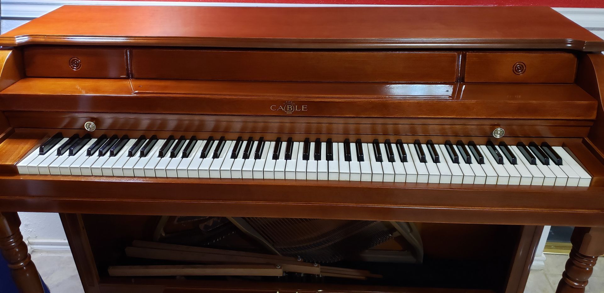 A piano is sitting on top of a wooden table in a room.