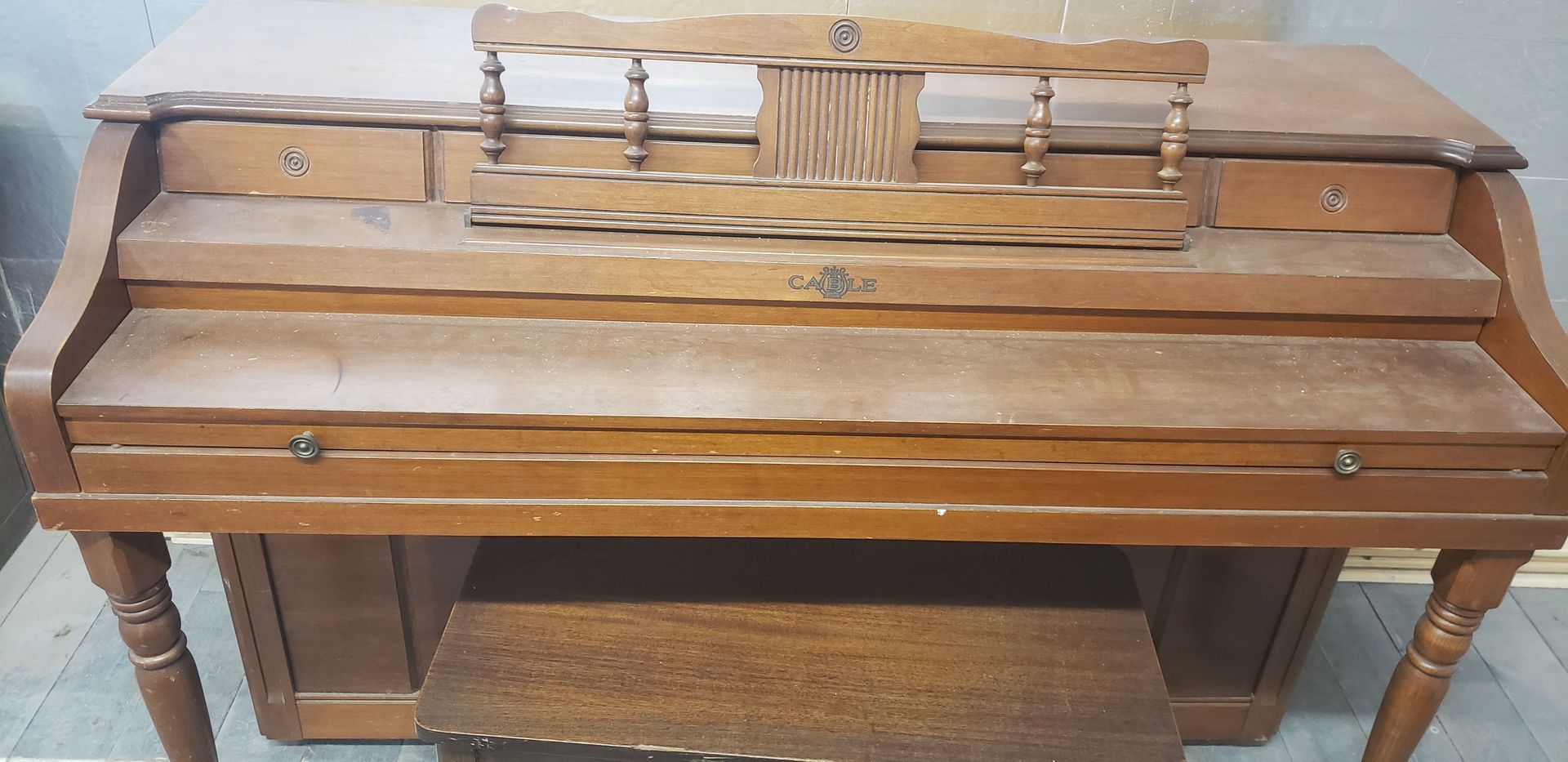 A wooden desk with a stool underneath it