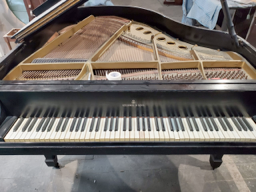 A black grand piano is sitting on a tiled floor