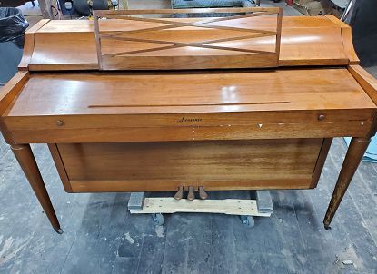 A wooden piano is sitting on top of a wooden table