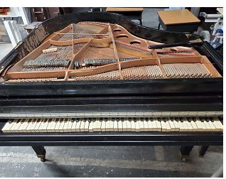 A grand piano is sitting on the floor in a room.