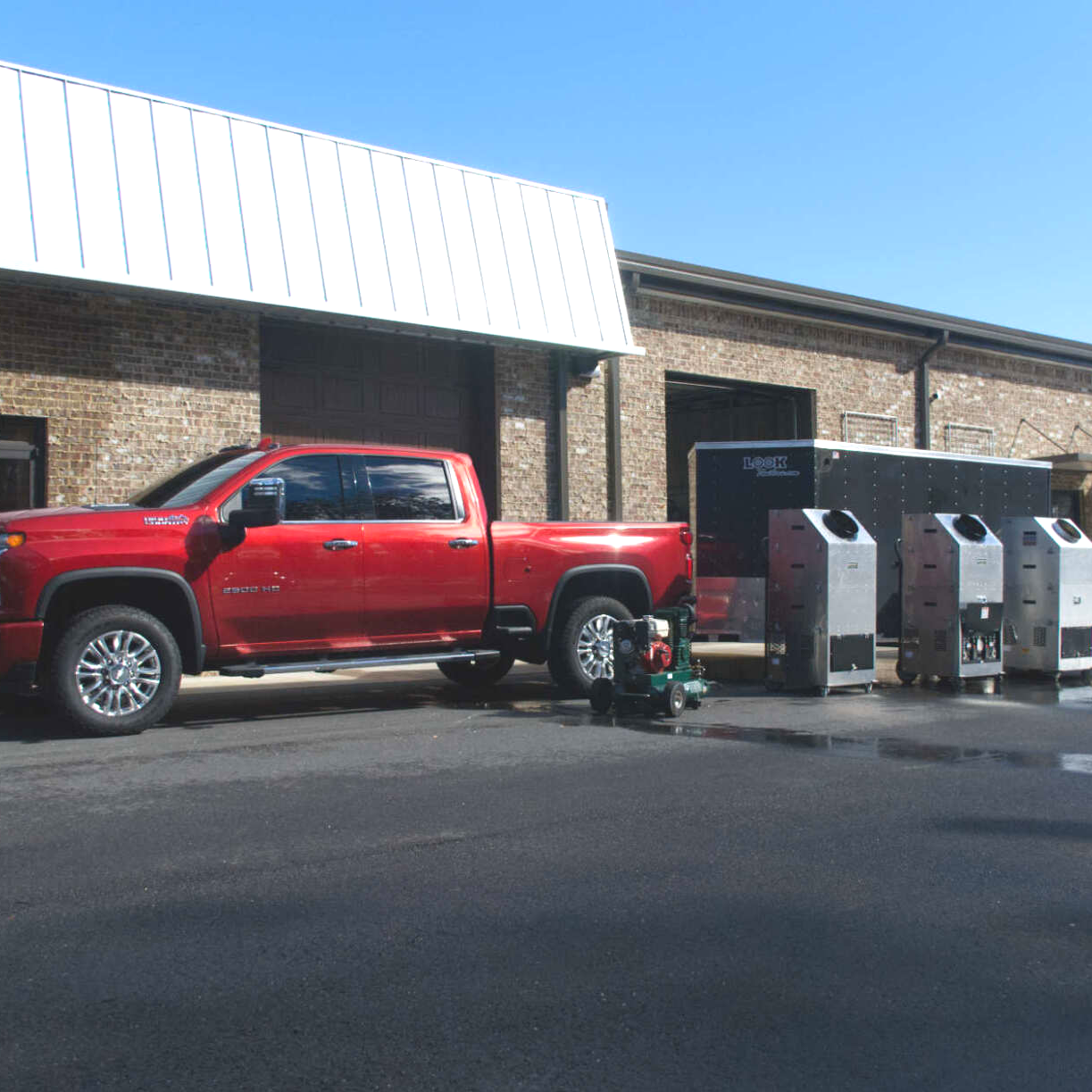 A red truck is parked in front of a building