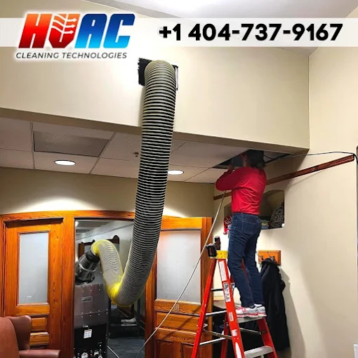 Person on ladder cleaning HVAC ductwork. Flexible hose connected to vent. Phone number on the top.