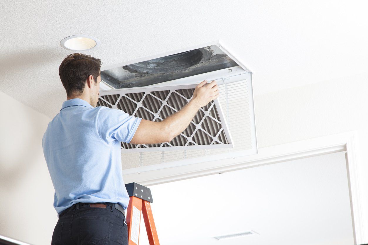 Male air duct maintenance cleaning a healthcare facility's air duct.