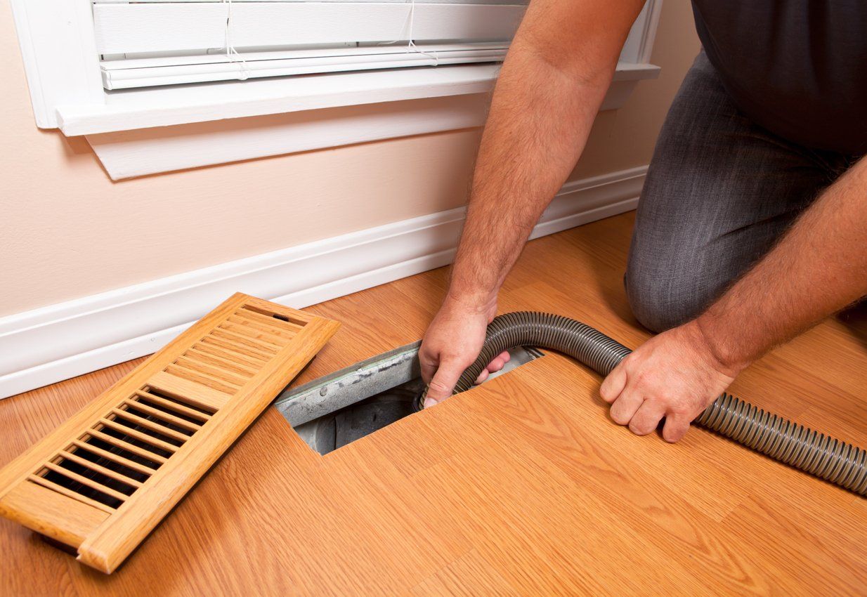 Male professional solving a property's mold problem by cleaning its air ducts with specialized tools.