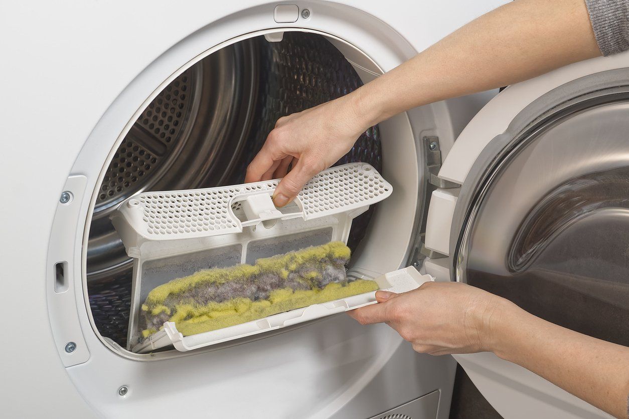 Dryer vent cleaning importance - Woman holding a dryer trap showing accumulation of lint.