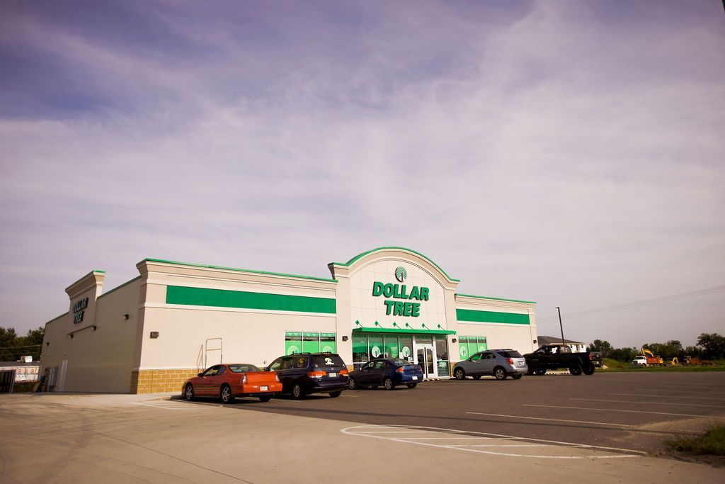 A dollar store with cars parked in front of it