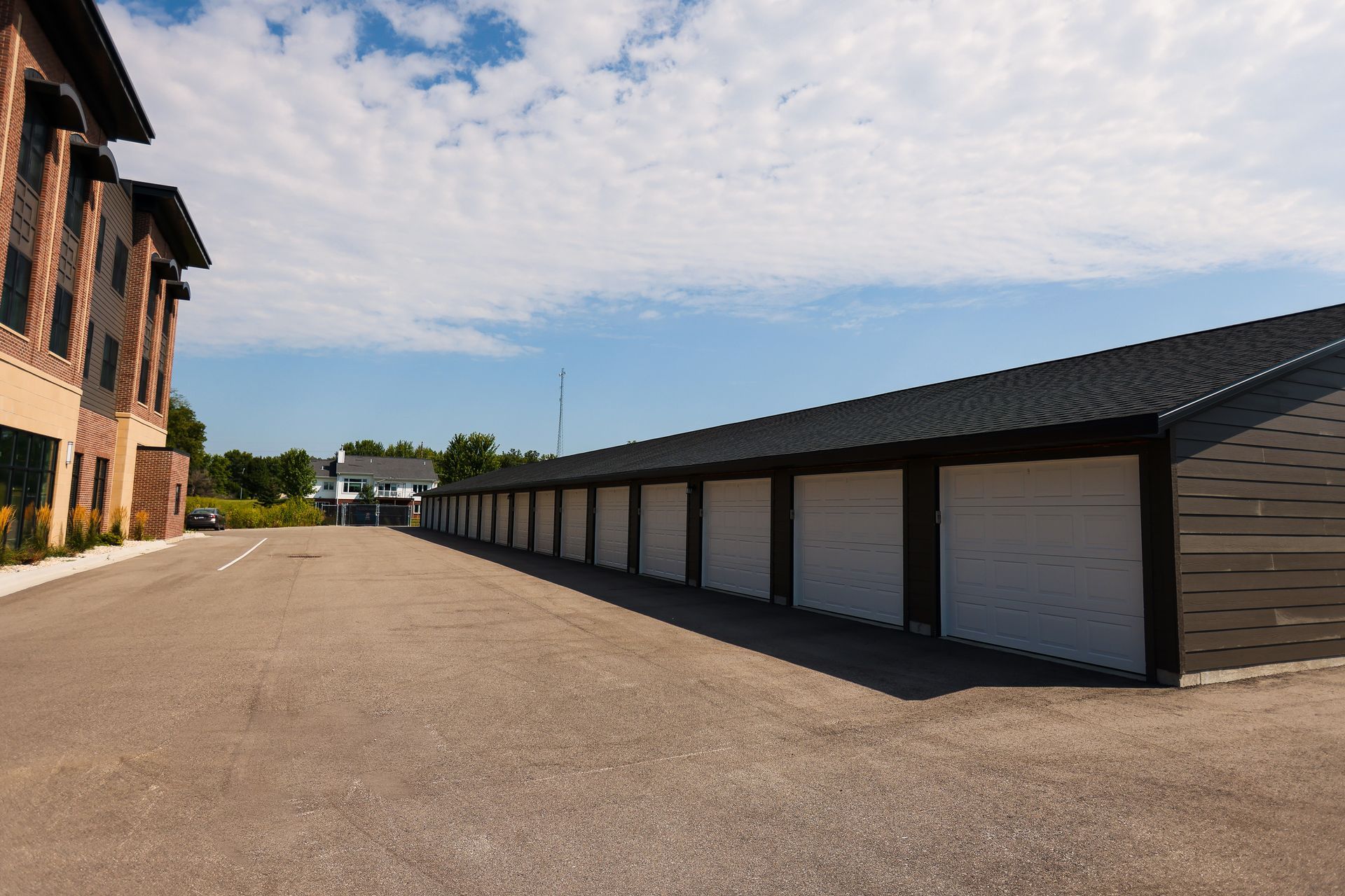 A row of garage doors are lined up on the side of a road.