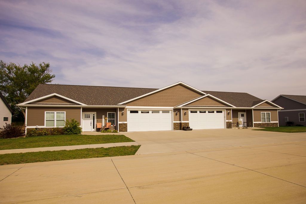 A house with three garages and a driveway in front of it