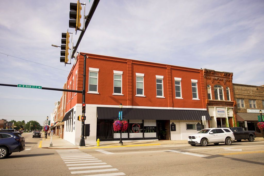 A red building is on the corner of a city street