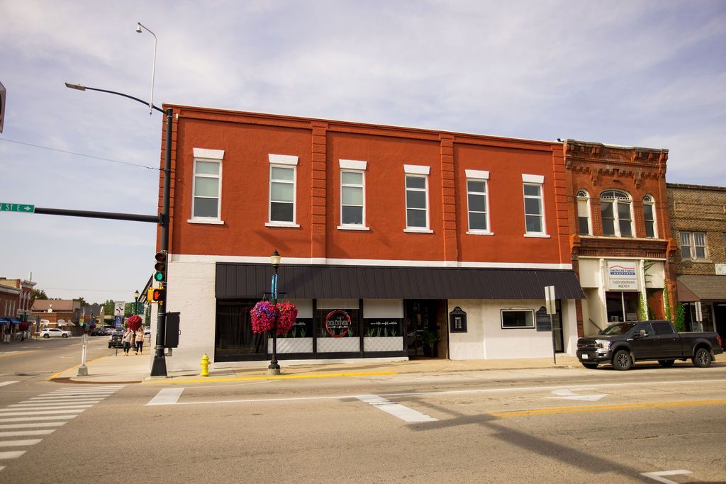 A red building with a black truck parked in front of it