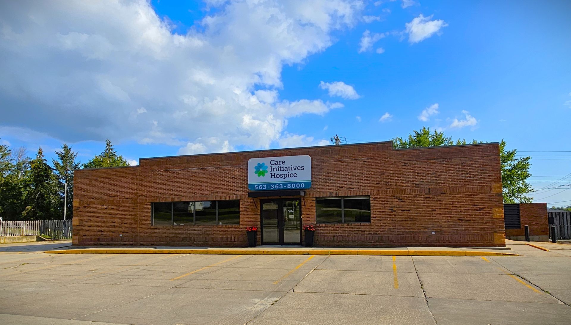 A large brick building with a blue sky and clouds in the background.